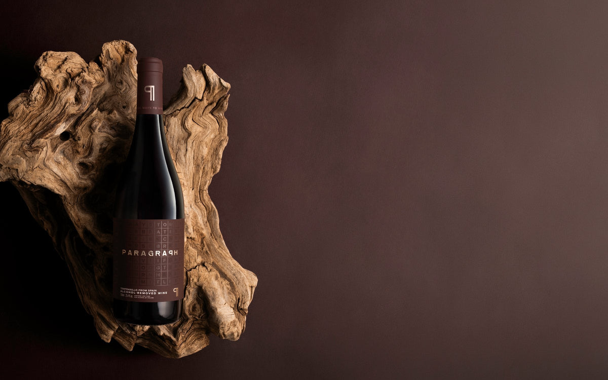 A bottle of PARAGRAPH Tempranillo on driftwood