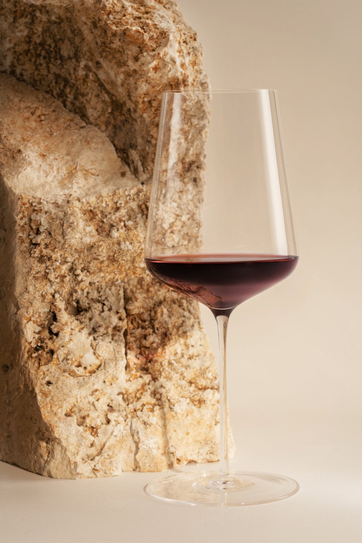A glass of PARAGRAPH Tempranillo on pale stone